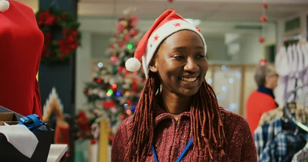 Счастливый Продавец Шляпе Санта Ходит Рядам Вешалок Украшенном Рождеством Магазине — стоковое фото