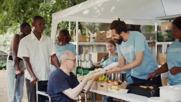 자발적인 개인은 굶주림과 빈곤에 싸우는 빈곤한 제안에 자유로운 음식을 기부한다 — 비디오