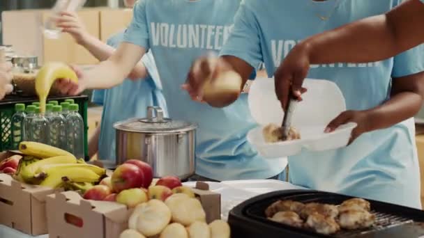 身穿蓝色T恤衫的多民族人聚集在外面分发食物捐赠 帮助无家可归和饥饿的人 关注志愿者为有需要的个人免费提供最新准备的膳食 — 图库视频影像