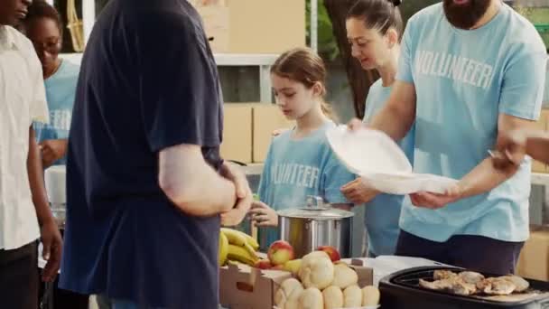 Férfi Női Önkéntesek Megosztják Ételt Ellátmányt Kevésbé Kiváltságosokkal Jótékonysági Étkezés — Stock videók