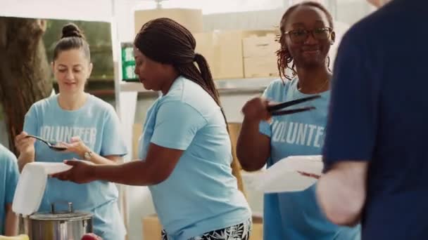 Utomhusmatbanken Erbjuder Multietniska Kvinnliga Volontärer Gratis Mat Till Hemlösa Män — Stockvideo