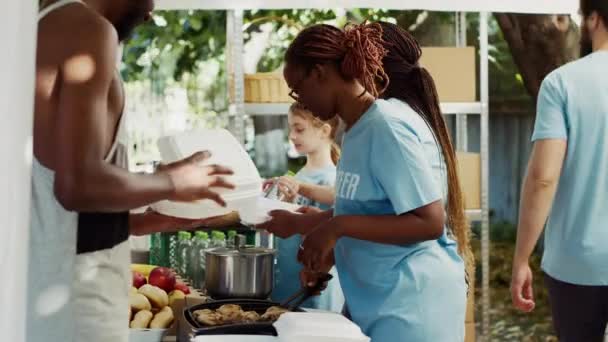 Junge Afroamerikanische Und Kaukasische Freiwillige Verteilen Kostenlose Lebensmittel Und Dinge — Stockvideo