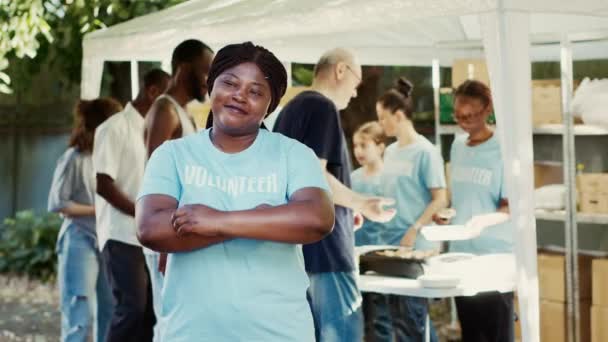在食物驱动的慈善活动中 非洲裔美国女性志愿者微笑并摆出姿势 向无家可归者和穷人提供救济和援助的人道主义援助方案 — 图库视频影像