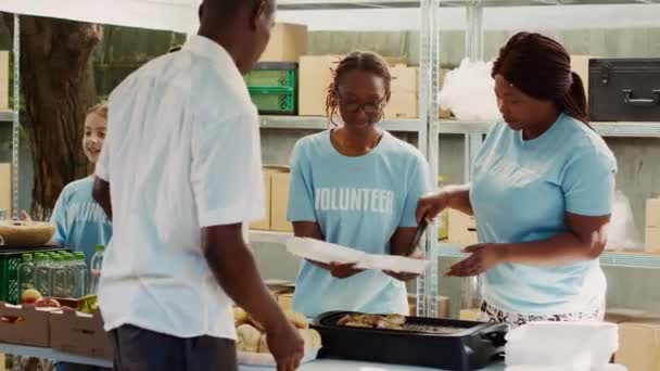 多种族志愿者女士为饥饿和无家可归的人提供膳食和不易腐坏的产品 友善的慈善工作者向穷人和有需要的人提供免费食物 三脚架射击 — 图库视频影像