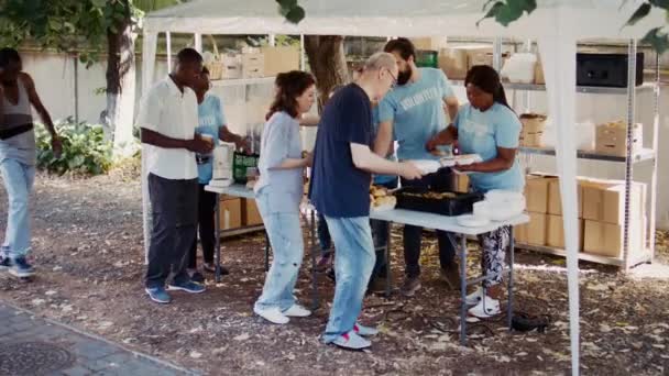 Мультирасовые Добровольцы Занимаются Благотворительностью Обеспечивая Теплой Едой Обездоленных Бездомных Некоммерческая — стоковое видео