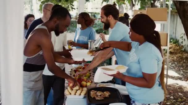 Съемка Бокового Обзора Захватом Благотворителей Раздающих Бесплатную Еду Бездомным Нуждающимся — стоковое видео