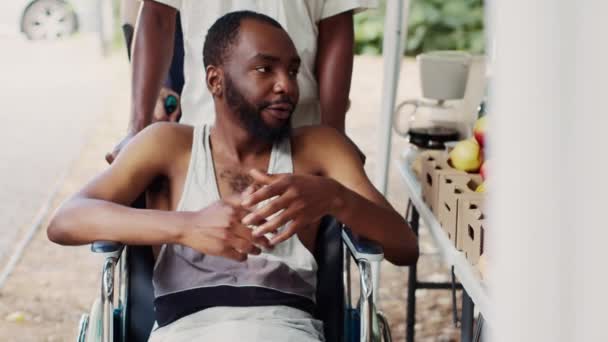 Gratis Mat Och Frukt Ges Till Rullstolsbunden Afrikansk Man Nöd — Stockvideo