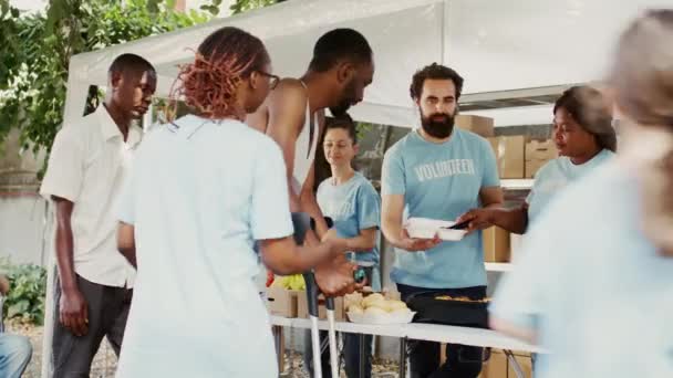Voluntária Afro Americana Ajudando Homem Usando Muletas Com Sua Refeição — Vídeo de Stock
