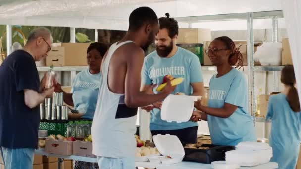 Багатокультурні Добровольці Поширюють Безкоштовну Їжу Необхідні Речі Малозабезпечених Добровільні Люди — стокове відео
