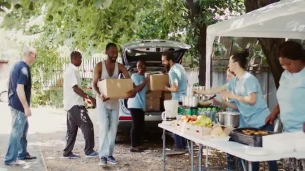有需要的人由敬业的志愿者提供饭盒和罐头食品 向代表食物运动和非营利组织的慈善工作者微笑 为无家可归者提供食物 — 图库视频影像