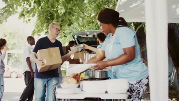 Сонячний День Багатоетнічні Добровольці Розподіляють Пожертвування Їжі Бідних Пропонуючи Допомогу — стокове відео