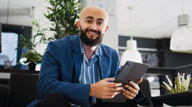 Ofiste tablet kullanan bir girişimci, yönetim kurulu brifingi için sunum yapıyor. Verileri ve aylık raporları kontrol eden Ortadoğu girişimcisi, AI geliştirici görevleri.