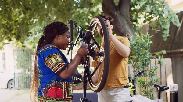 Pasangan Interrasial Aktif Luar Menyesuaikan Roda Sepeda Dengan Peralatan Profesional — Stok Foto