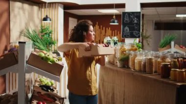 Sıfır atık deposu titiz bir müşteri organik ve kimyasalların bedava olduğundan emin olmak için elmaları karıştırıyor. Yerel market müşterisi taze toplanmış doğal meyveler alıyor