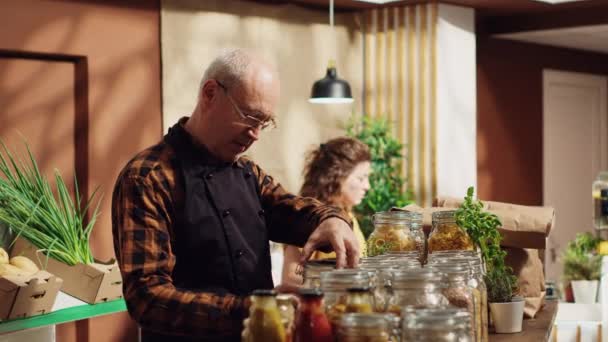 Porträt Eines Lächelnden Alten Supermarktbesitzers Der Zersetzbare Glasbehälter Für Seine — Stockvideo