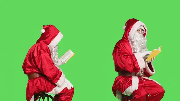 聪明的圣诞老人在绿屏的背景下看书 坐在椅子上欣赏诗歌或文学书籍 自信的男人 穿着父亲的衣服 有着演讲的嗜好和知识 — 图库照片