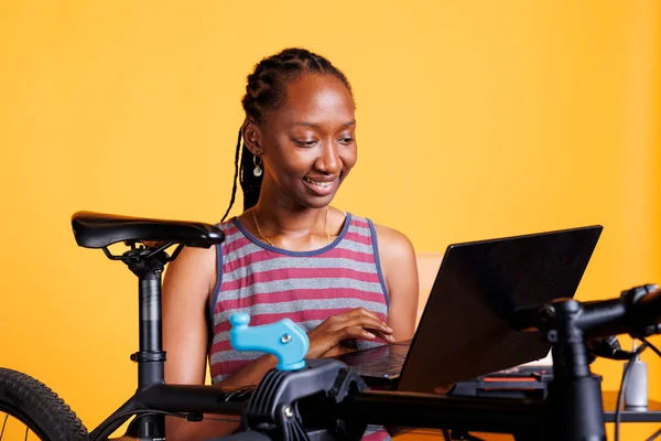 Dedicated African American Female Cyclist Using Laptop Research Bike Maintenance — Stock Photo, Image