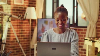 Afroamerikan vatandaşı ev ofisinde blog yazıyor, gün batımını seyrediyor ve günlük aktiviteleri tamamlıyor. Bağımsız olarak online kariyer geliştirmeye çalışan, çoklu görev becerilerini geliştiren bir tele-işçi..