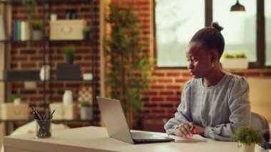 Teleworker görevler hakkında notlar alıyor, iş yerindeki online kariyer verimliliğine yardımcı olmak için dizüstü bilgisayar planlayıcısı kullanıyor. Afrikalı Amerikalı serbest yazar ilham kaynağı olarak fikirler yazıyor, gün batımı saati..