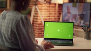 Serbest Çalışan, uzaktan e-ticaret projesi üzerinde çalışırken bilgisayardaki izole modelleme şablonuna bakarak yeşil ekran kullanıyor. Afrikalı Amerikalı kişi kromakey teknolojisiyle çalışıyor..