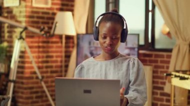 Freelancer görüntülü konuşma yapıyor, online serbest çalışma projesi üzerinde çalışıyor ve kendi programını yapıyor. Afrika kökenli Amerikalı serbest çalışan kişi gün batımında uzak görevlerde çalışıyor..
