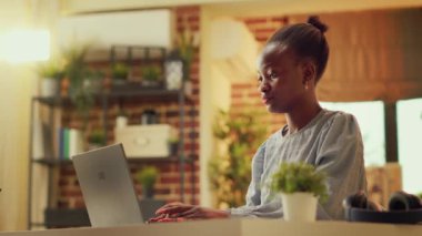 Afrika kökenli Amerikalı kadın gün batımında evde çalışıyor, kişisel web sitesinde blog makalesi yayınlıyor. Çevrimiçi e-ticareti geliştirmeye çalışan serbest çalışan biri. El kamerasıyla..