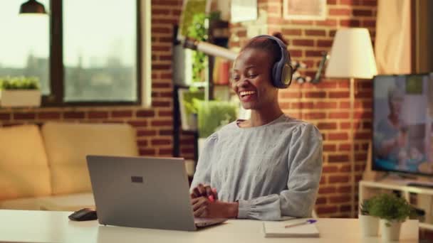 电报局的工作人员通过视频和朋友聊天 做轻松的自由职业项目 并制定自己的时间表 在笔记本电脑上做远程工作的非裔美国妇女 — 图库视频影像