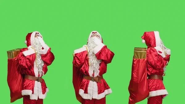 疲惫的圣徒尼克在绿屏的背景下打呵欠 厌倦了带着礼物和玩具去参加圣诞节前夕的活动 圣诞老人的化身在工作室里感到困倦 — 图库照片