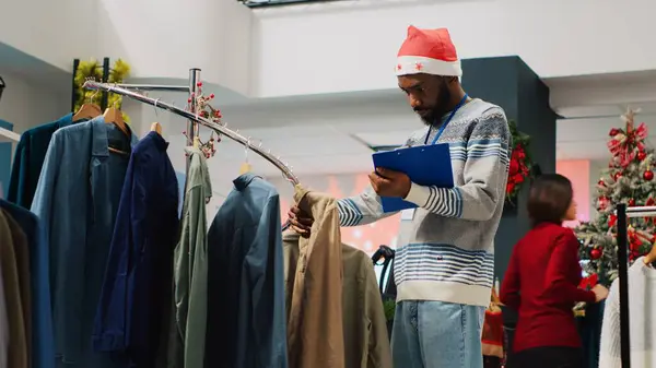 Einzelhandelskaufmann Stöbert Kleiderständern Weihnachtlich Dekorierten Modegeschäften Und Checkt Preisschilder Mit — Stockfoto