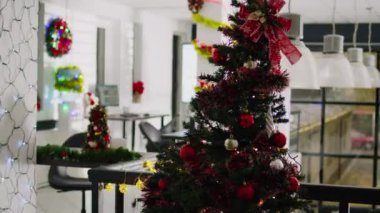 Güzel dekore edilmiş Noel ağacıyla süslü modern ofis çalışma alanı boş. Xmas 'taki bilgisayar ekranlarındaki iş grafikleri kış tatili boyunca işyerlerini süslüyor