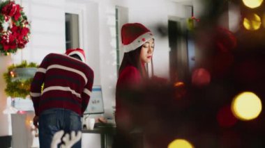 Şenlikli ofis dekorasyonundaki üzgün personel, iş yerindeki son gününde iş arkadaşları tarafından teselli edilen masa eşyalarına el koyuyor. Noel 'de işten kovulan, Xmas şapkalı Asyalı kadın, çalışma merkezini boşaltıyor.