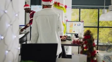 Noel döneminde, takım liderinin denetim sürecini gösteren, süslü püslü ofiste çalışan Asyalı bir çalışan. Çok ırklı xmas 'larda muhasebe çözme projesi tatil sezonunda işyerini süslüyor