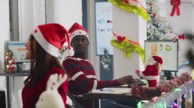 Aşırı mutlu Afrikalı Amerikalı işçi Noel Baba 'dan Noel Baba' dan hediyeler alıyor. Noel ofis partisinden önce kılık değiştirmiş iş arkadaşından hediye alan heyecanlı bir çalışan.