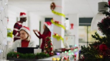 Noel süslemeli ofis çalışanları geç kalmış proje üzerinde çalışırken kaygısız iş arkadaşları dekorasyonlara bakarak birlikte eğleniyorlar. Xmas 'taki stresli işçi çalışma alanını süsledi