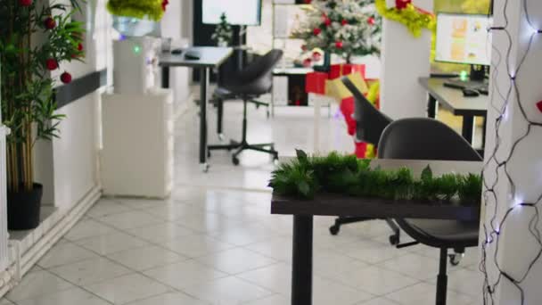 美しいクリスマスツリーとライトで空のお祝いを飾る現代オフィスワークスペースのチルトアップショット Xmasは冬の休暇の前に祭りの準備ができている職場を飾ります — ストック動画