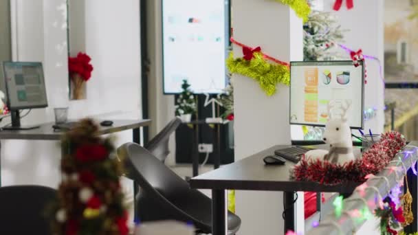 空荡荡的节日华丽的办公室 为公司的圣诞庆典适当装饰 圣诞节期间 在没有员工的工作场所 电脑显示屏上的会计数据会显示出他们的工作环境 — 图库视频影像