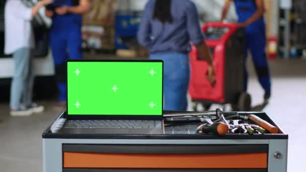 Зеленый Экран Ноутбука Установленного Рабочей Скамейке Оживленном Гараже Рядом Профессиональными — стоковое видео