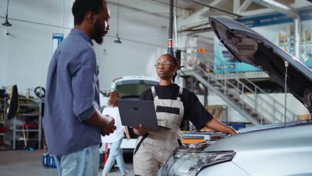 자격을 엔지니어는 노트북을 사용하여 가게에서 고객에게 필요한 자동차 수정을 작성합니다 — 비디오