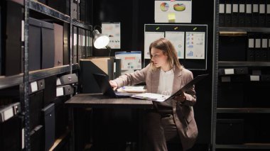 Kanun adamı odaya giriyor, ipuçlarını analiz etmek ve kapsamlı bir araştırma yapmak için dizüstü bilgisayarını kullanıyor. Ofis alanı suç analizi için ekipmanlarla donatılmıştır ve dosya ve klasörlerle doludur..