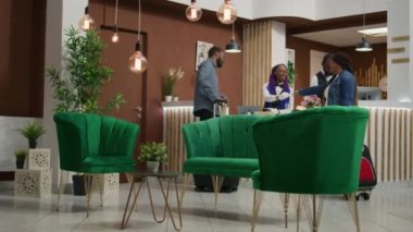 Misafirler harika bir tatilden sonra resepsiyona oda anahtarını bırakıyorlar, kontrol ediyorlar ve eve dönüyorlar. Afrikalı Amerikalı çift otel kapıcılarına lüks hizmetleri için teşekkür ediyor..