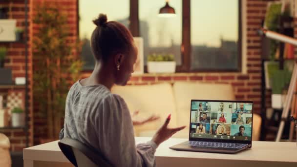 ビデオコールのアフリカ系アメリカ人の成人は タスクを解決するための更新と新しい研究計画のブリーフィングセッションを行います ラップトップとウェブカムを使用して オンラインビデオ会議で振る女性 — ストック動画