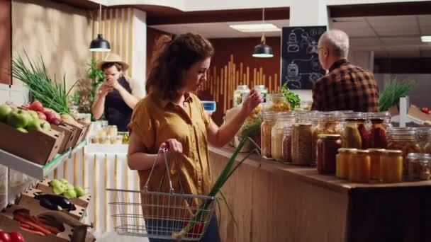 ゼロ廃棄物のスーパーマーケットの顧客は ショッピングバスケットに健康的な自然なパントリーのステープルを追加し ショットで人形をローミングします 地元の食料品店 化学薬品のための買い物客 無料のバルク食品項目 — ストック動画