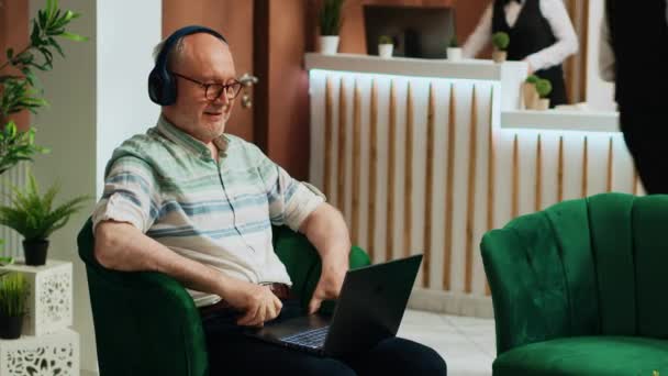 Starszy Mężczyzna Ogląda Filmy Laptopie Korzysta Streamingu Online Hotelowym Lobby — Wideo stockowe