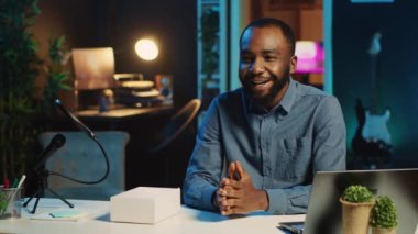 BIPOC teknik içerik yaratıcısı yeni çıkan akıllı telefonun teknoloji değerlendirmesini kaydediyor, paketini açıyor ve izleyicilere parametreleri sunuyor. İnternet yıldızı abonelere telefon gösteriyor