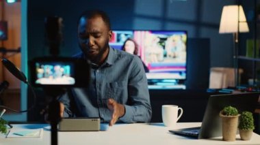 Afrika kökenli Amerikalı internet yıldızı çevrimiçi platform kanalı için kablosuz portatif hoparlörleri inceliyor. BIPOC etkileyicisi hayran kitlesine müzik çalma aygıtı sunuyor