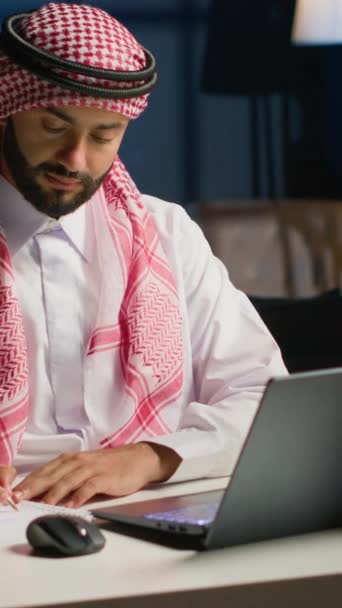 Вертикальное Видео Мусульманский Предприниматель Работает Дома Используя Ноутбук Записи Ближневосточный — стоковое видео