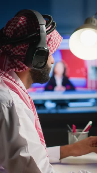 Vídeo Vertical Fotógrafo Musulmán Que Usa Auriculares Mientras Edita Proyecto — Vídeos de Stock