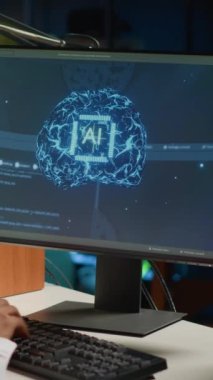 Dikey video bilişim yöneticisi bilgisayar kullanarak yapay zeka sistemlerini güncelliyor, ikili kod betikleri yazıyor. Yapay zekayı geliştirmek için programlama kullanarak evden çalışan teknik destek danışmanı