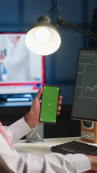 Bilgisayardaki Yıllık Rapor Grafiklerine Bakarken Elinde Yeşil Ekran Akıllı Telefon — Stok video