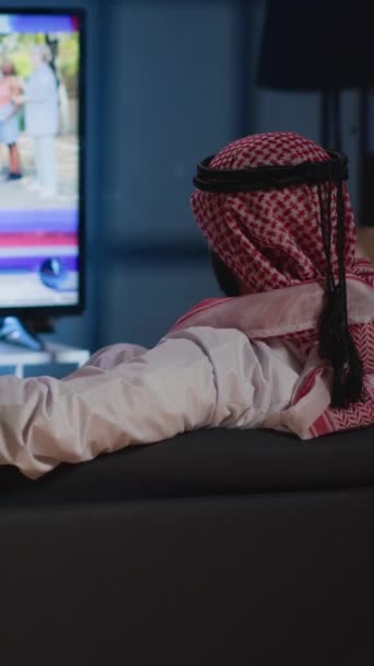 Vídeo Vertical Hombre Árabe Descansó Sofá Acogedor Viendo Las Noticias — Vídeos de Stock